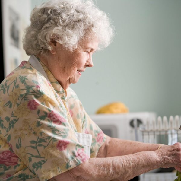 Elderly woman washing vegetables