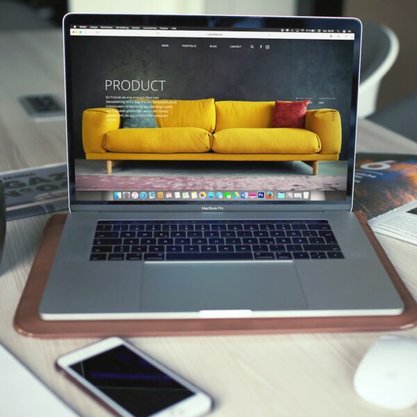 Laptop on a table showing a sofa product page on a furniture store website